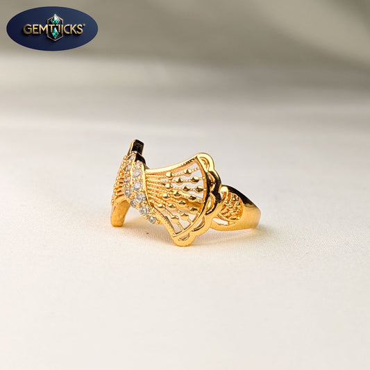 Gold ring with intricate design on a light background, featuring Gemticks logo.