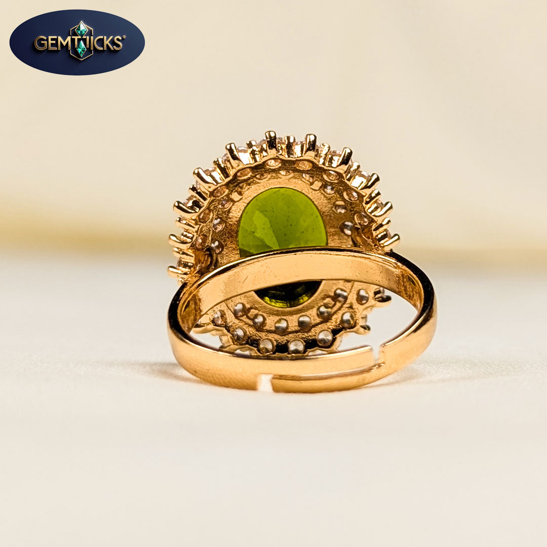 Gold ring with green gemstone on a beige background, featuring Gemticks logo.
