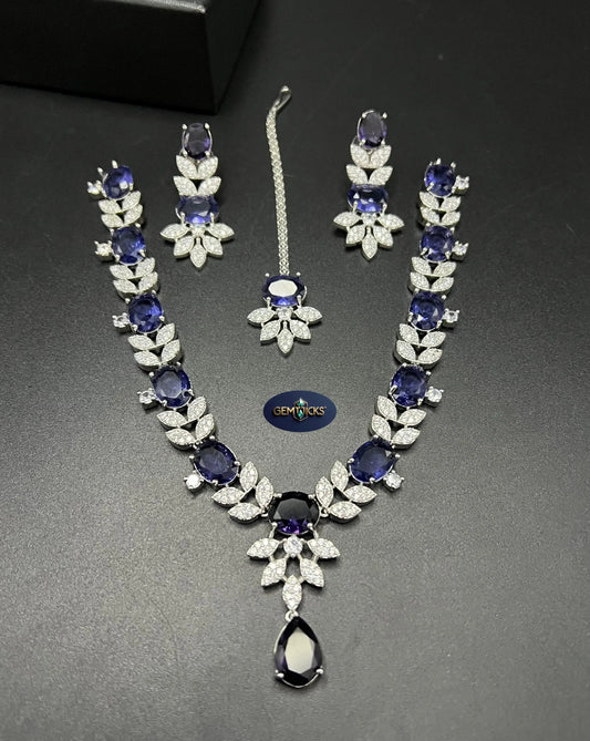 remium Sapphire Blue American Diamond 1-carat necklace set with matching earrings and tikka on a black background.